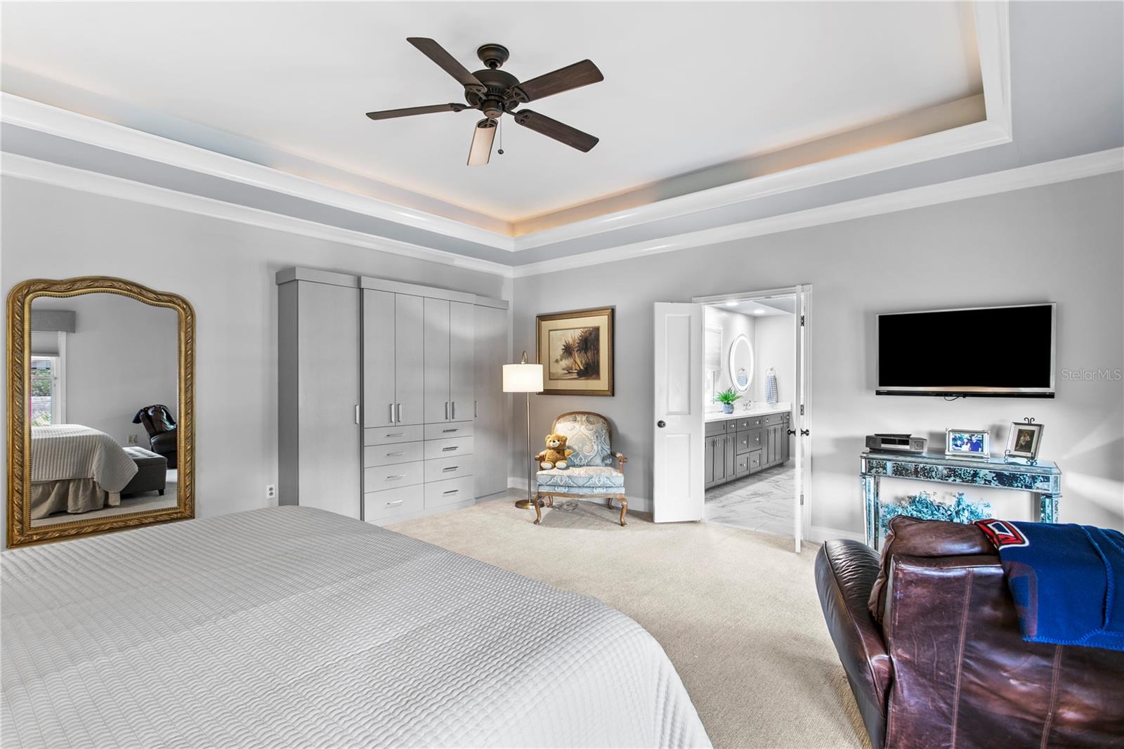 The spacious primary suite features custom cabinetry for added clothing storage and organization.