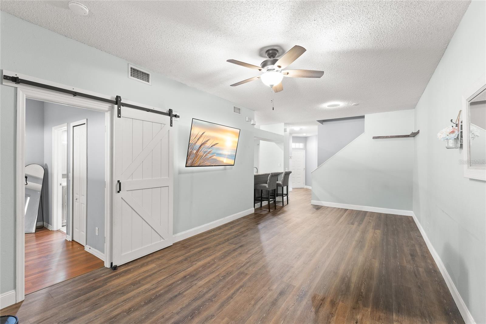 Barn-style sliding doors create an architectural transition to the first-floor primary suite.