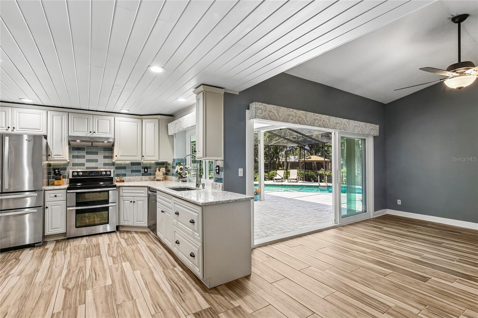 Beautifully renovated kitchen with ship lap ceilings, soft close 42 inch cabinets, glass back splash, new appliances new floors, pass through to the lanai, and quartz countertops.  View into the family room
