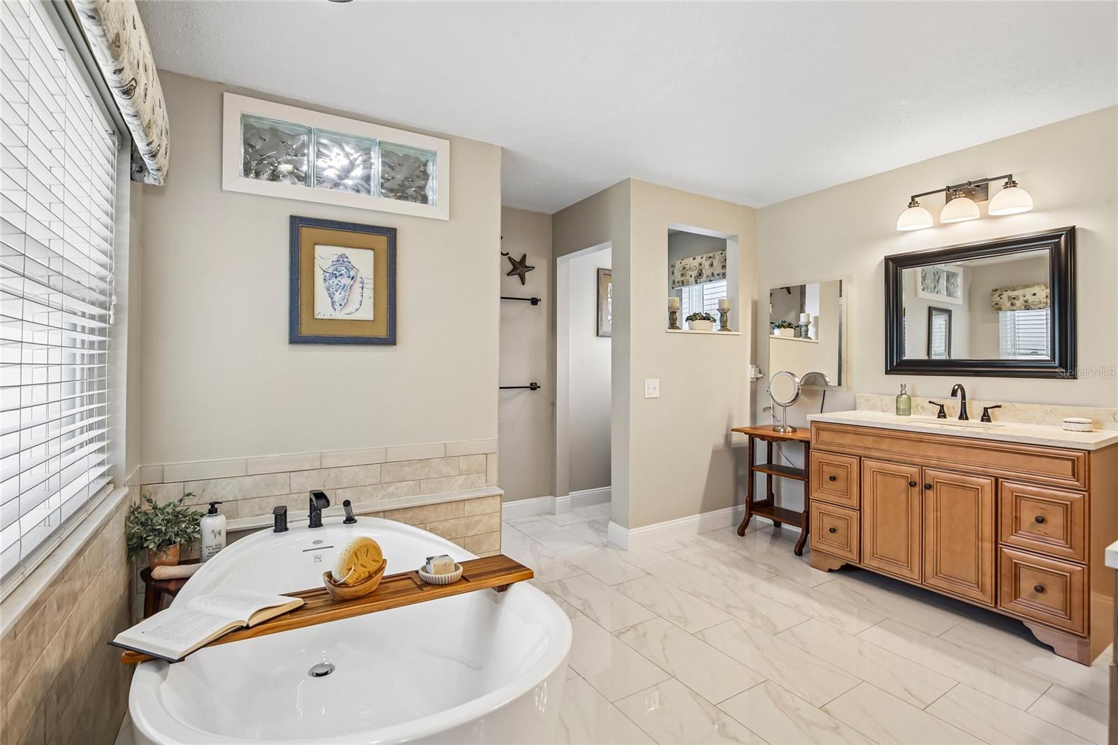 Primary Bathroom with marble floors, free standing tub, 2 large vanities and a walk in shower