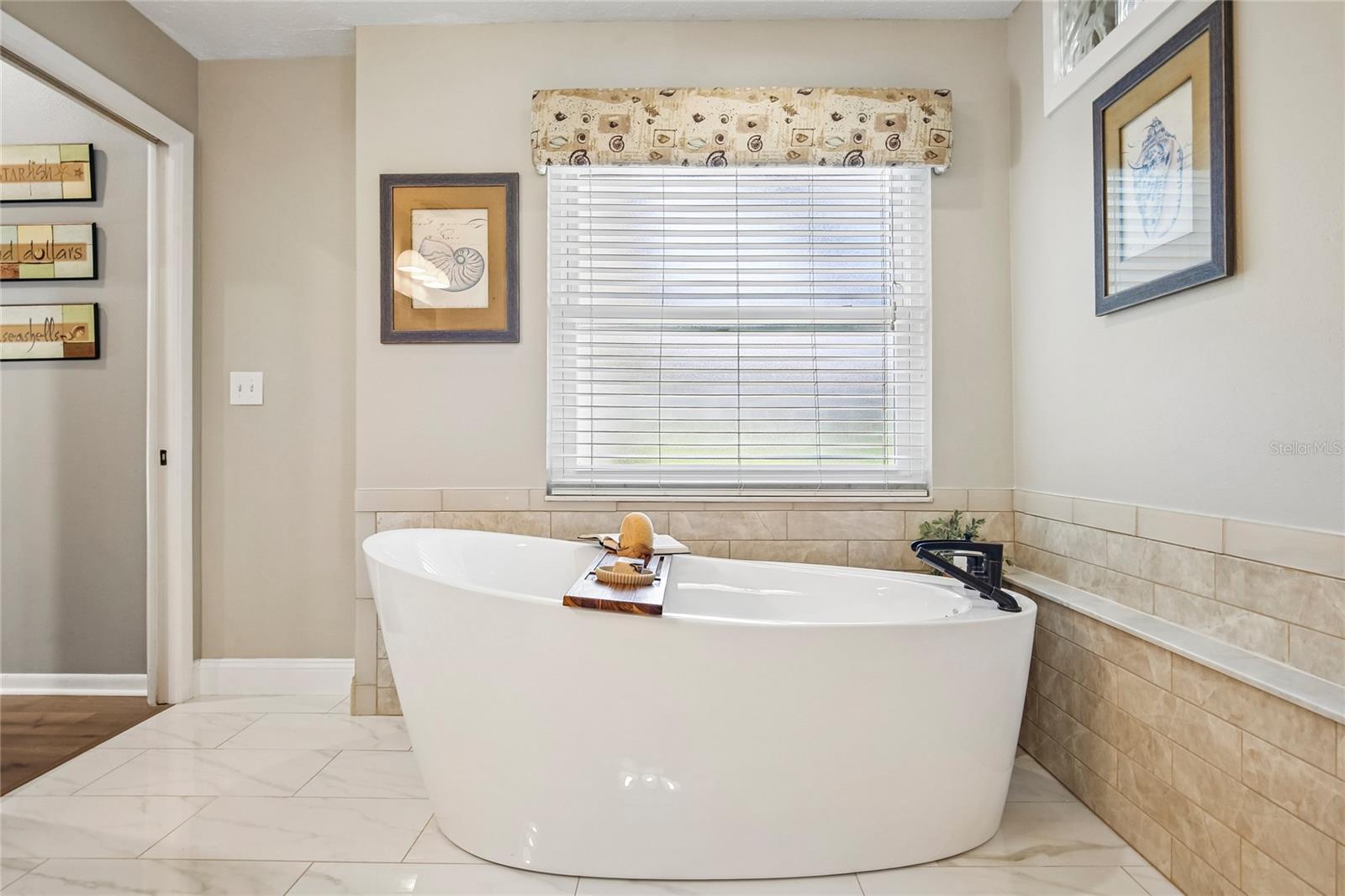 Primary Bathroom with marble floors, free standing tub, 2 large vanities and a walk in shower