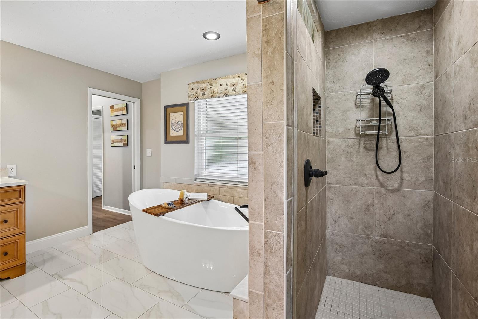 Primary Bathroom with marble floors, free standing tub, 2 large vanities and a walk in shower
