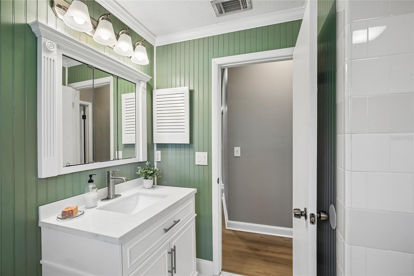 Renovated Bathroom with new vanity, marble floors, bead board, fixtures and shower