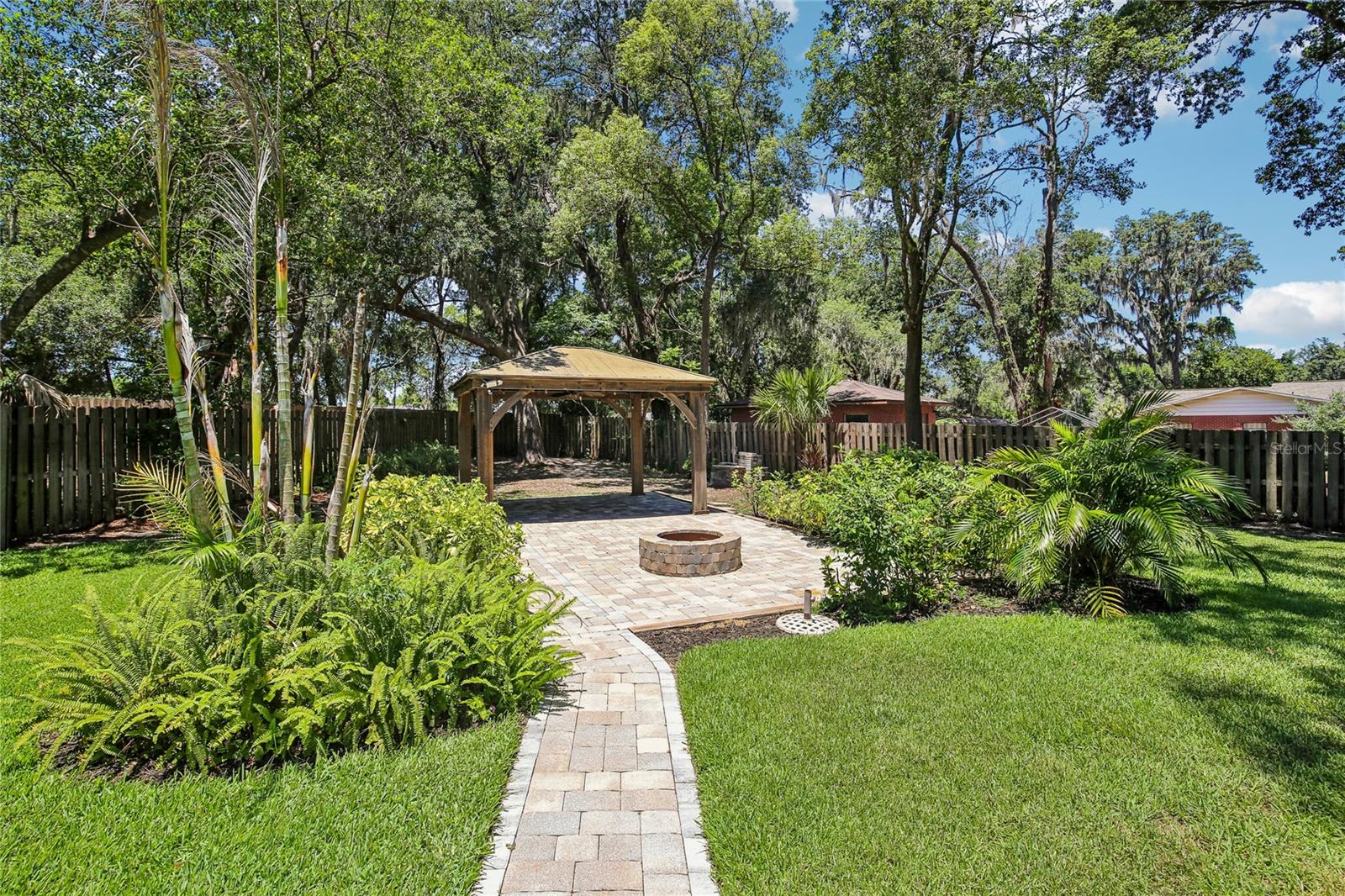 Paved walkway to back yard gazebo and fire pit