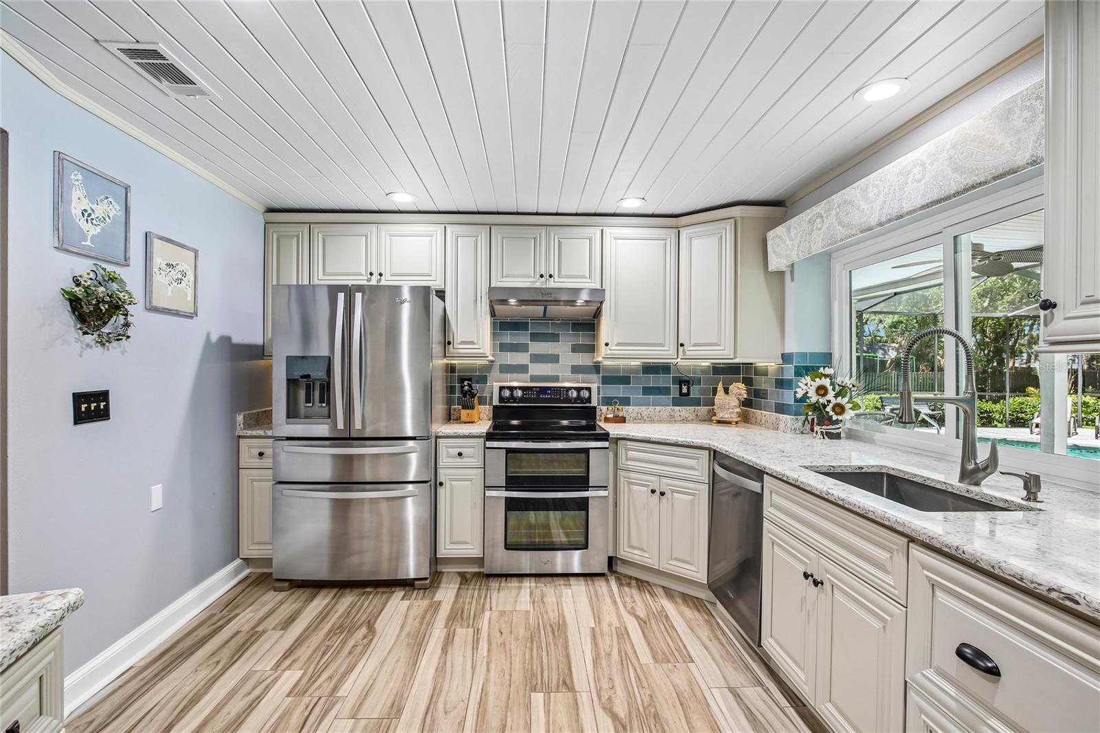 Beautifully renovated kitchen with ship lap ceilings, soft close 42 inch cabinets, glass back splash, new appliances new floors, pass through to the lanai, and quartz countertops