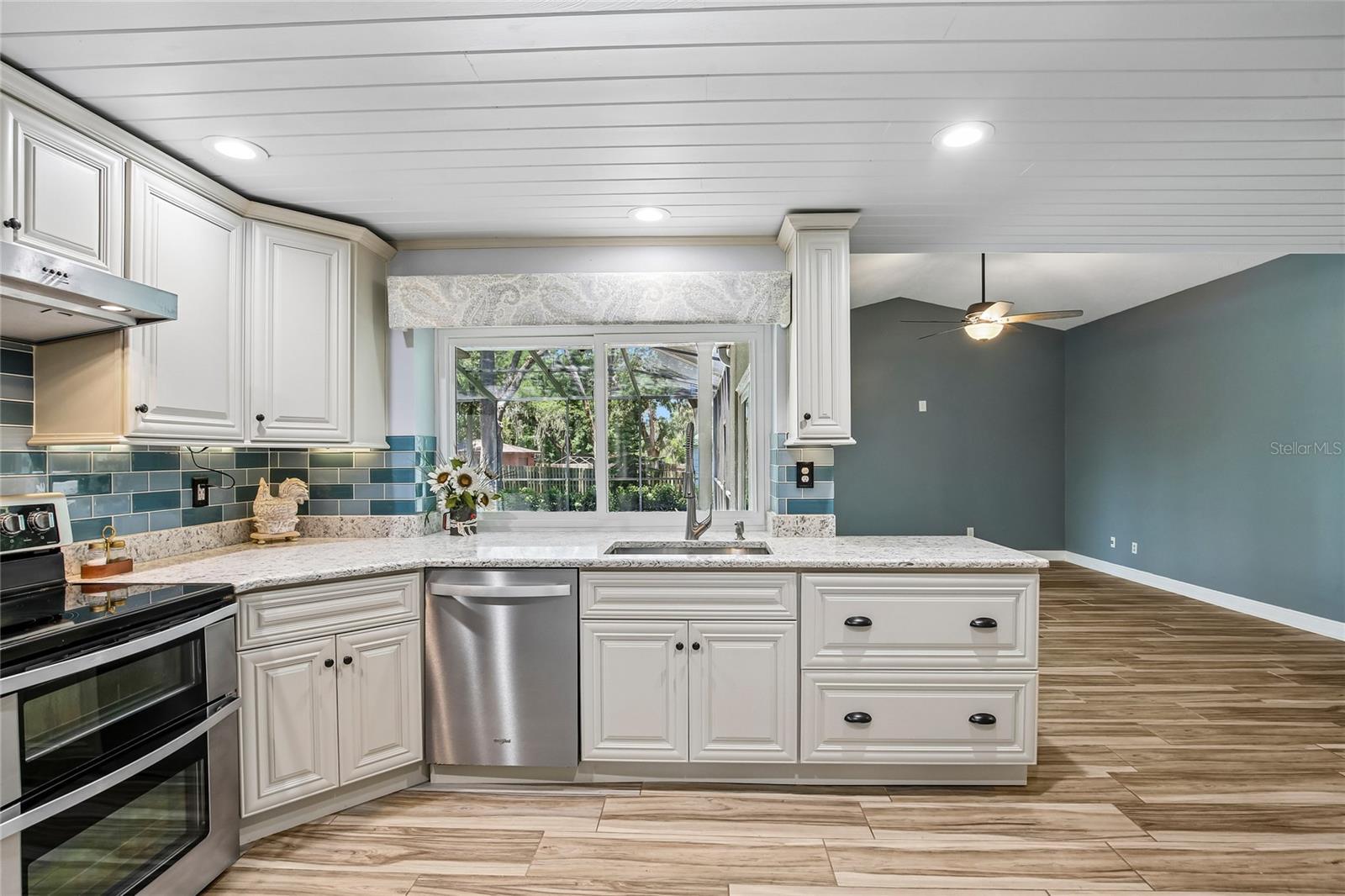 Beautifully renovated kitchen with ship lap ceilings, soft close 42 inch cabinets, glass back splash, new appliances new floors, pass through to the lanai, and quartz countertops