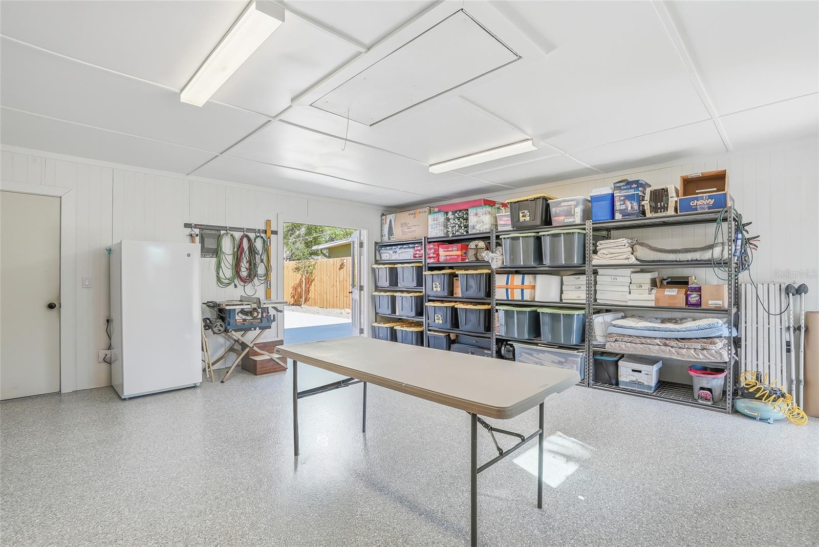 Clean workshop with doors on either side and has an window unit a/c