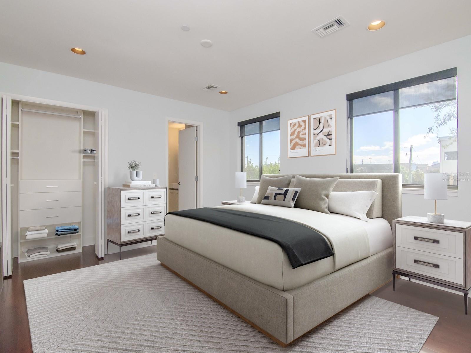 3rd level - Virtually staged spacious owner’s suite featuring a beautifully appointed bath with soaking tub, dual vanities, and remodeled walk-in shower, plus two custom California Closet systems including a generous walk-in closet.