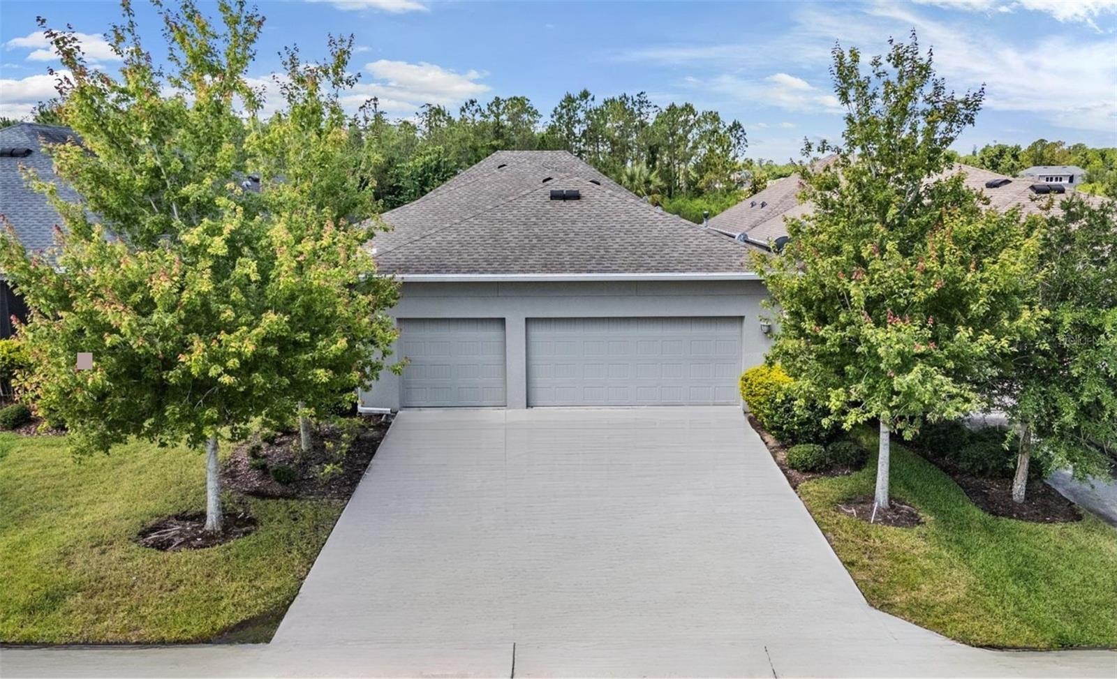 Mature landscaping frames the home with a 3 car garage