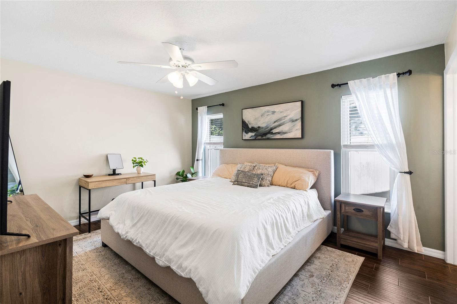 Spacious primary bedroom with wood look tile floors