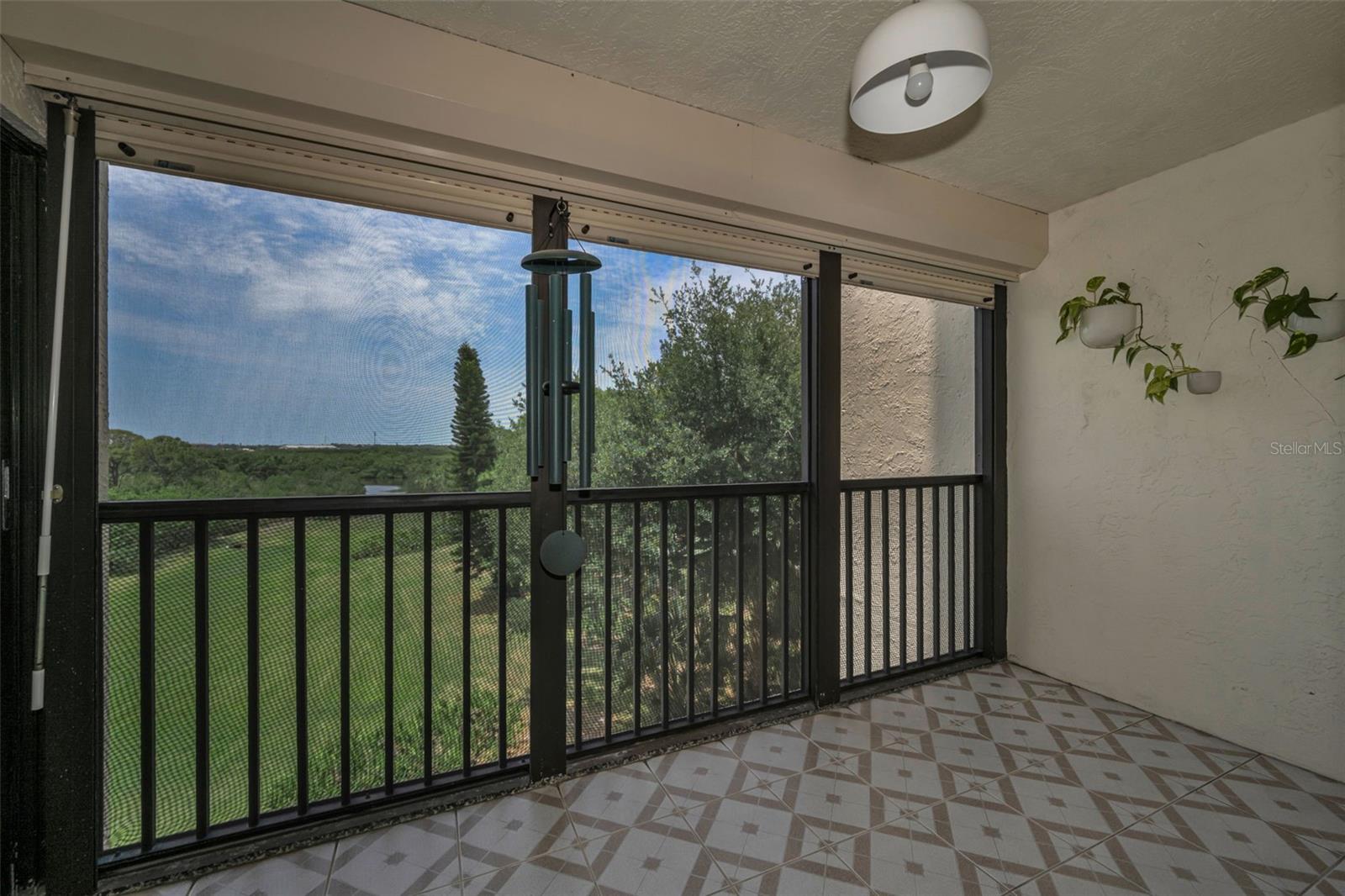 Rear, screened balcony overlooking plush landscaping and more. Beautifully tiled!