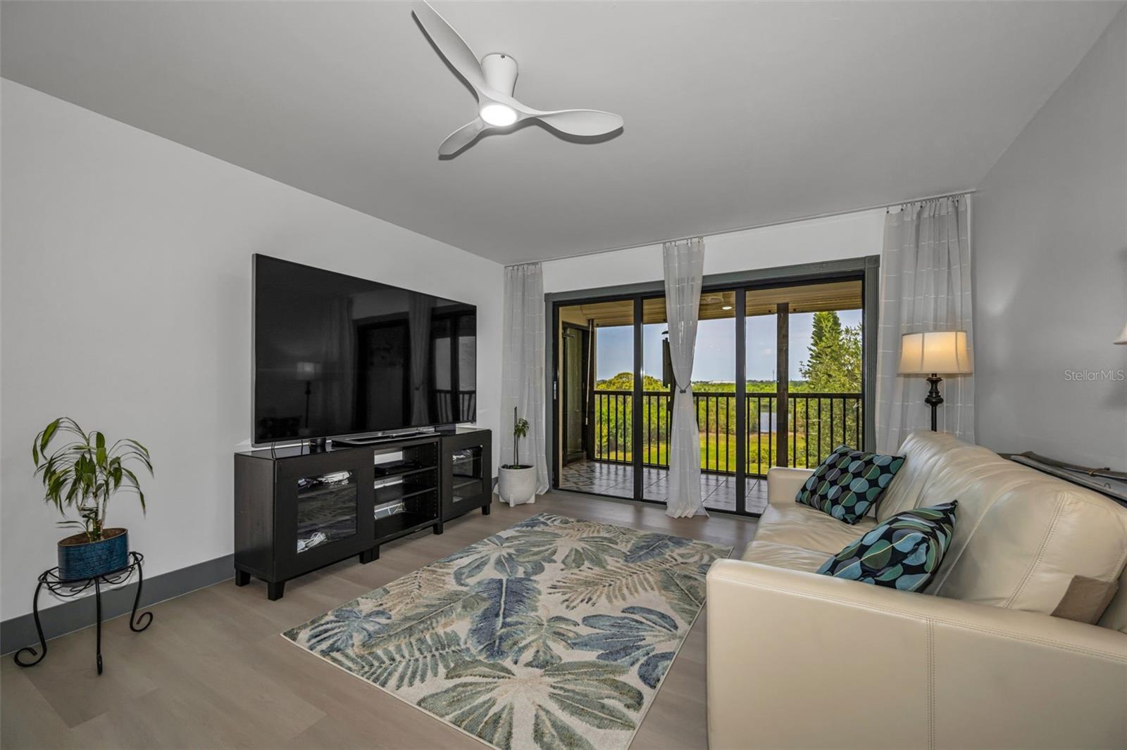 Living room with view out balcony and beyond!  All new vinyl plank flooring.