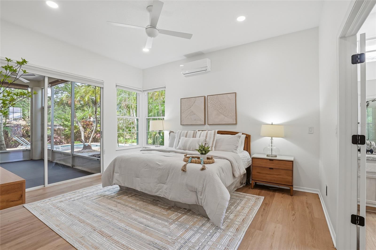 West wing of the home features a spacious primary bedroom suite with a pool view.