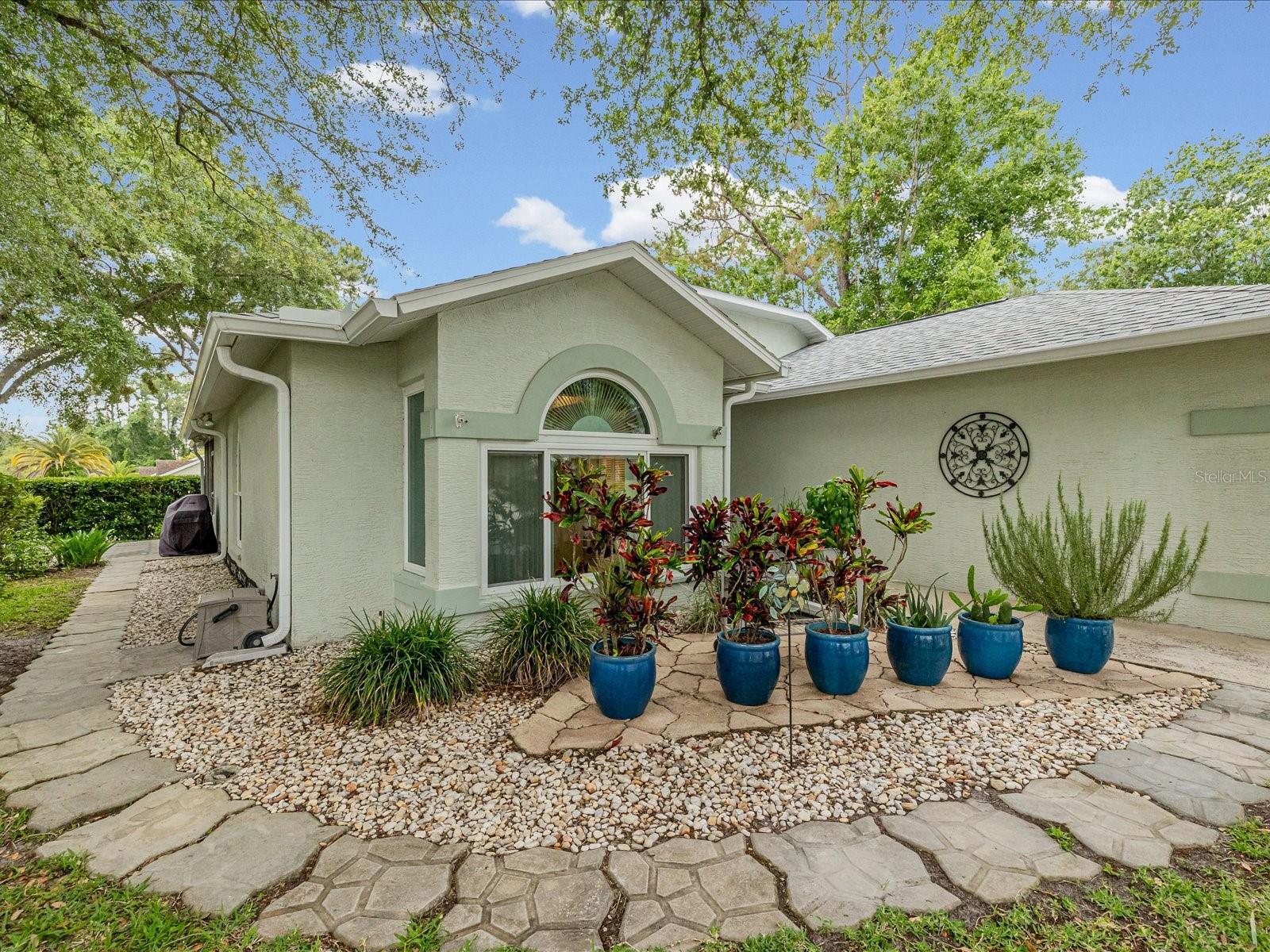 Front of home with walkway to side patio