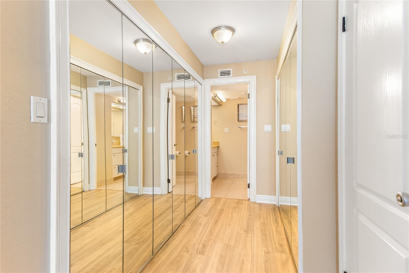 Master bedroom with a walk in closet and additional walls of closets.