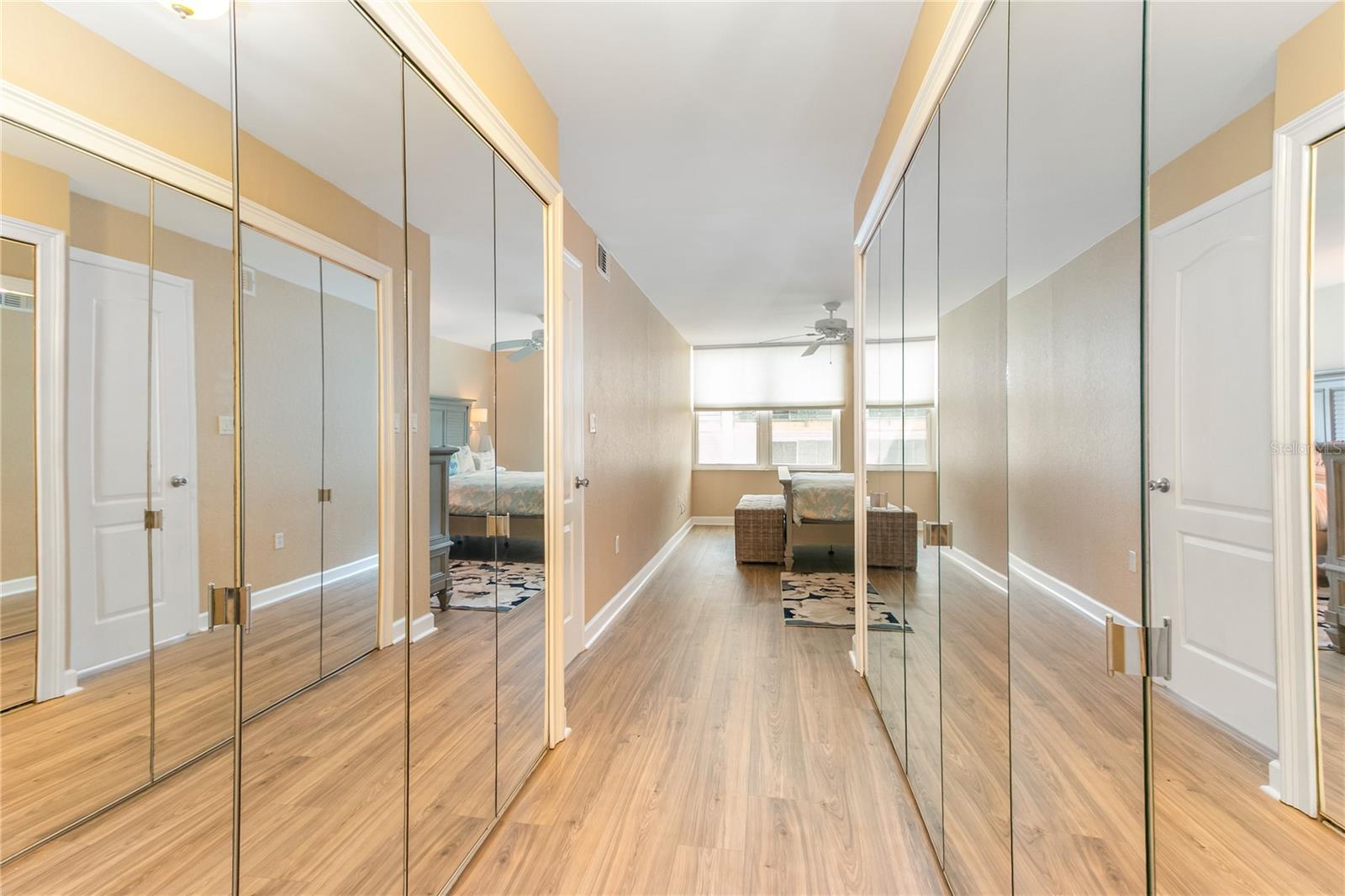 Master bedroom with a walk in closet and additional walls of closets.