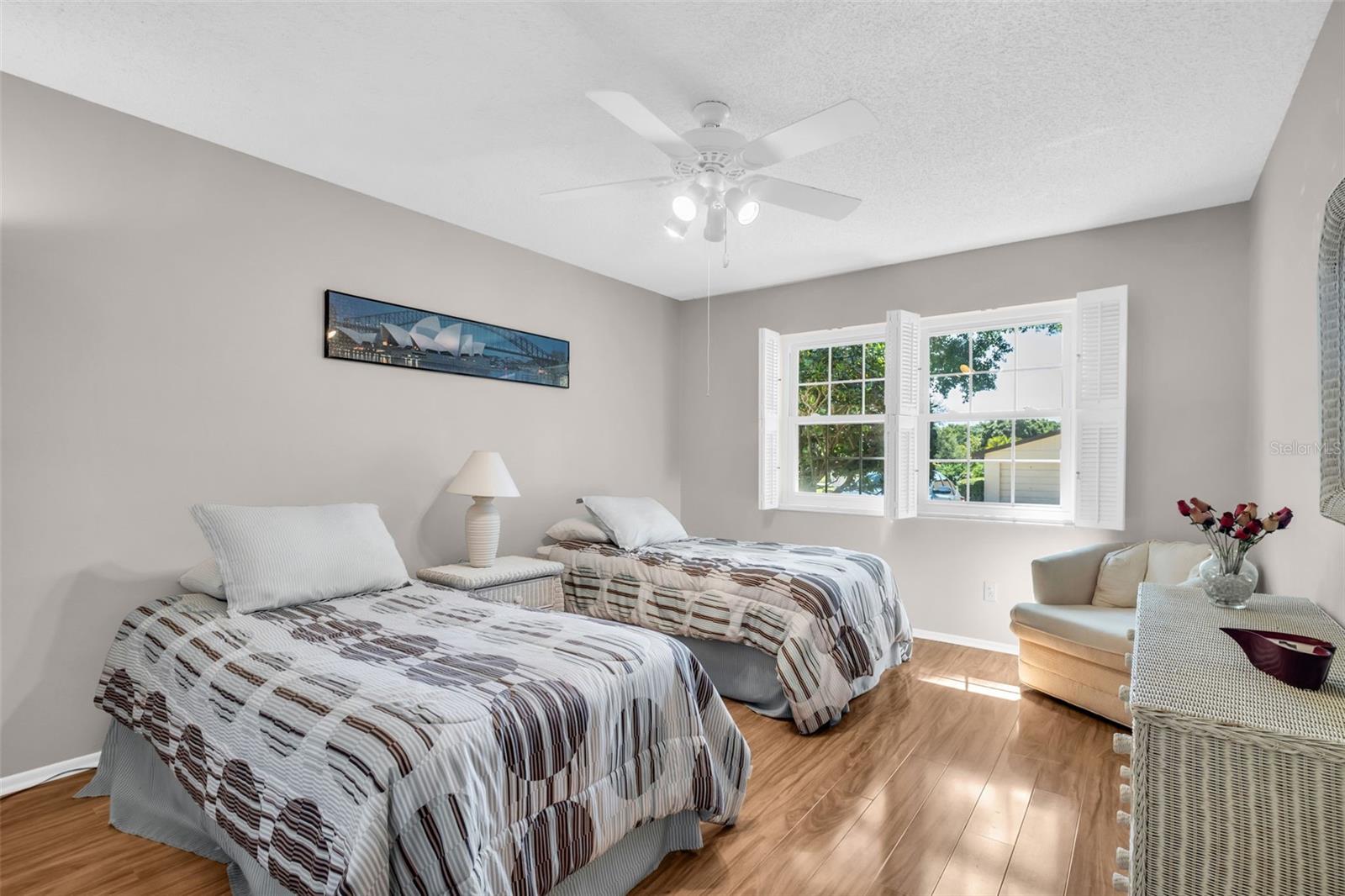 Spacious second bedroom - hurricane windows and white wooden shutters ~