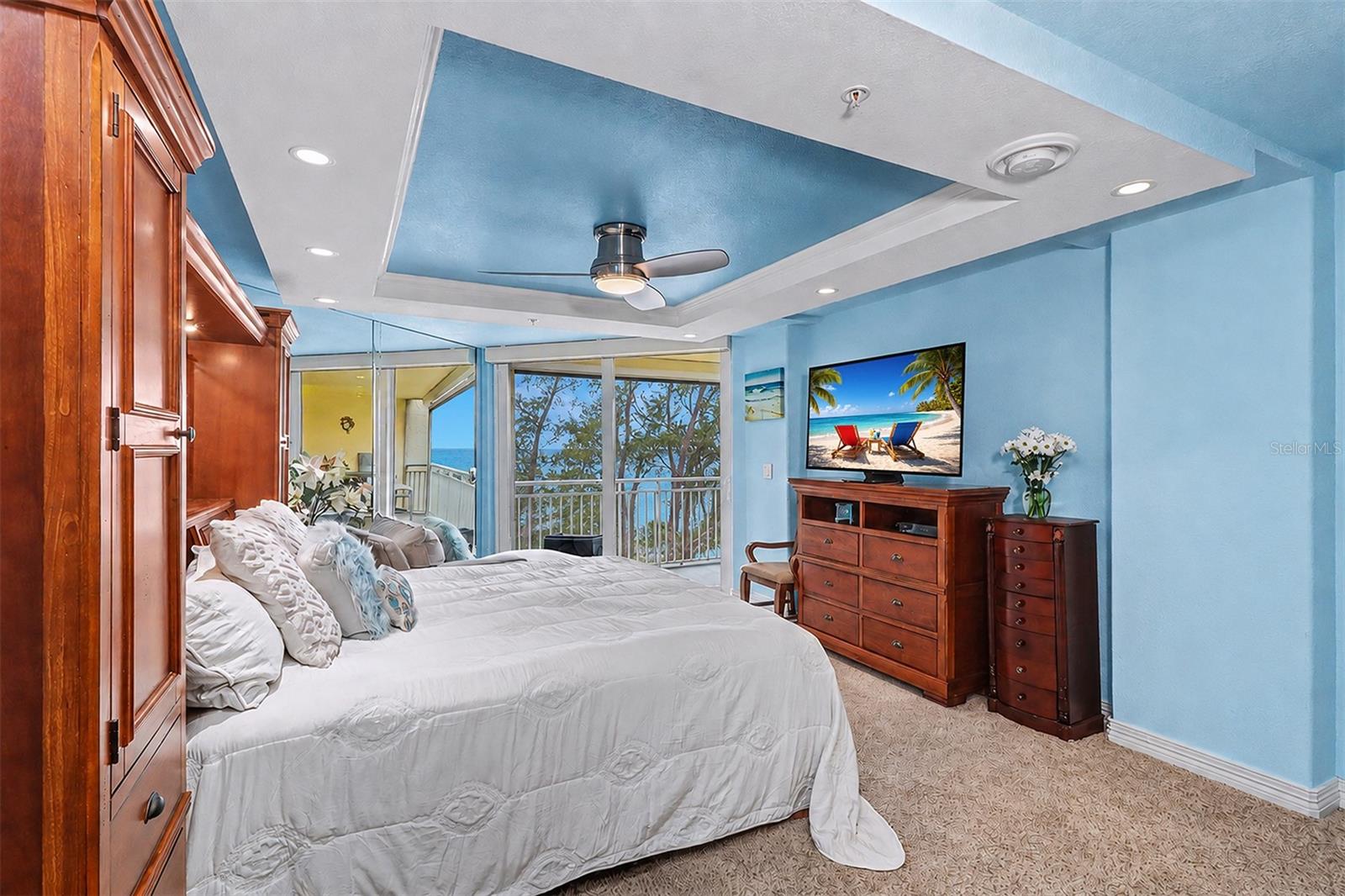 Primary Suite captures sweeping Gulf views and features direct balcony access, an adjustable split-top king bed, tray ceiling with ceiling fan, and TV—your own spacious private seaside sanctuary.