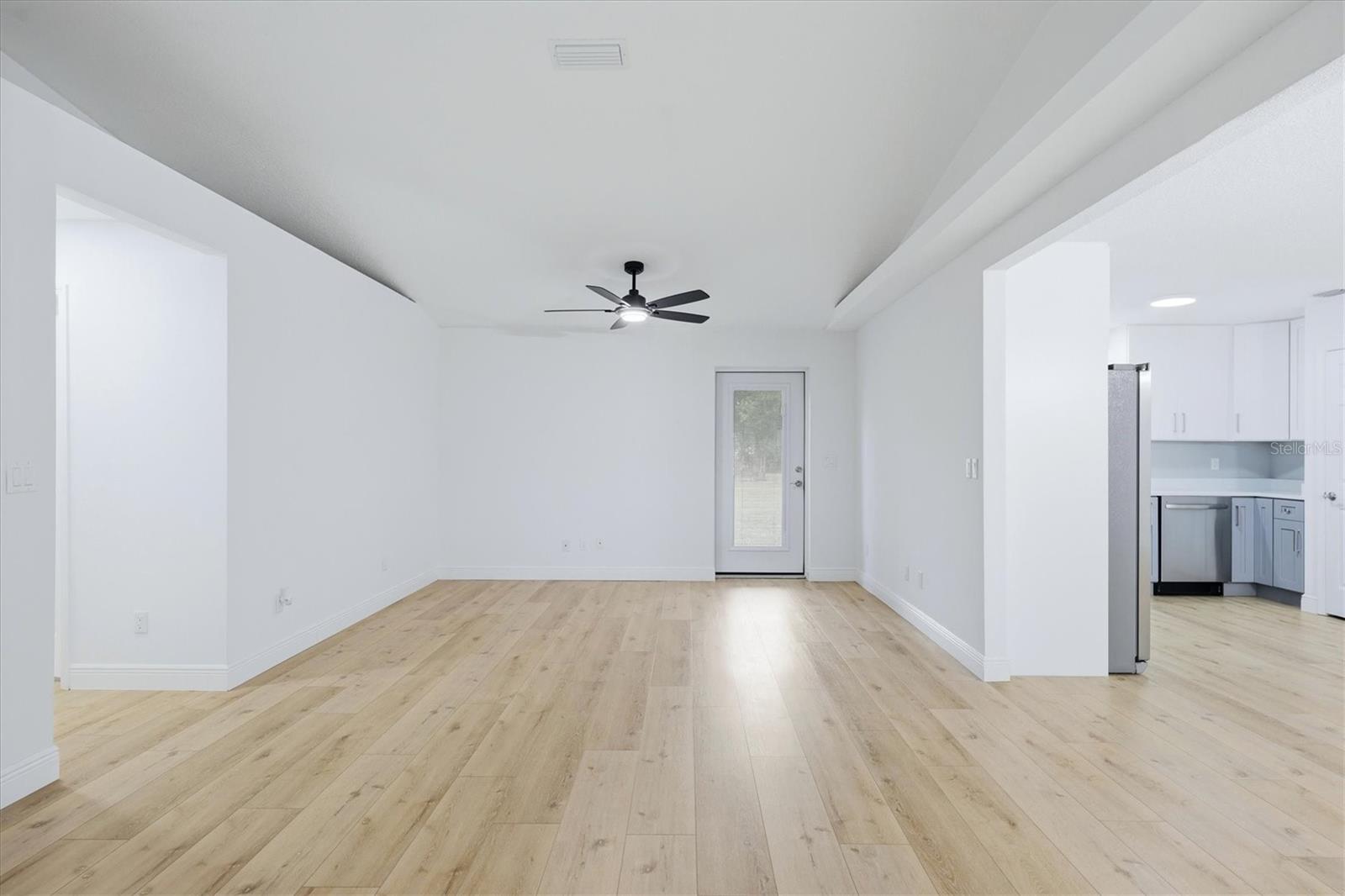 Enter home into spacious living area with dual ceiling fans and access to the back patio