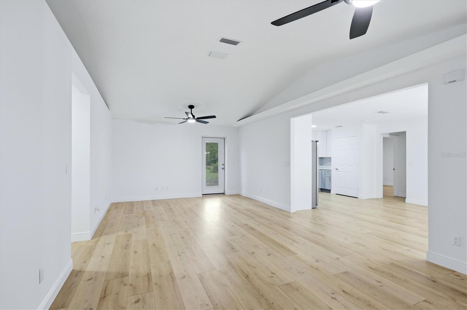 Vaulted ceilings with plant shelves adorn each side of the living area.