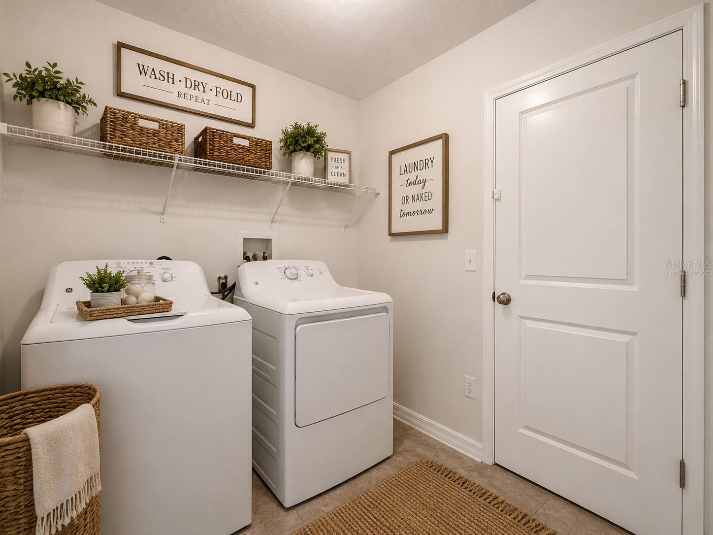 Laundry room leading to garage. Virtually staged.