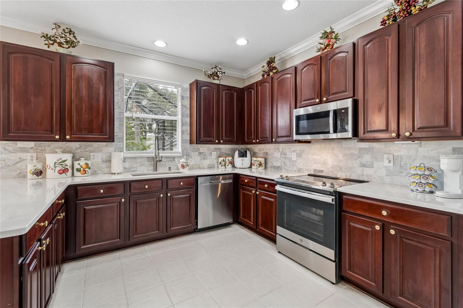 extensive backsplash perfectly blended with the rich 42” upper Cherry cabinets