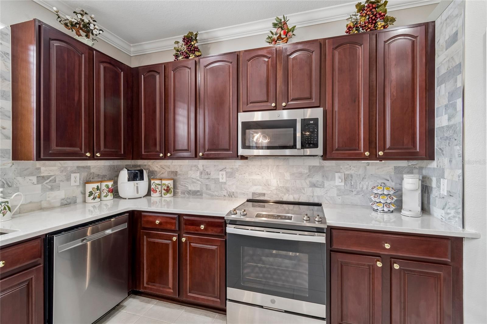 extensive backsplash perfectly blended with the rich 42” upper Cherry cabinets
