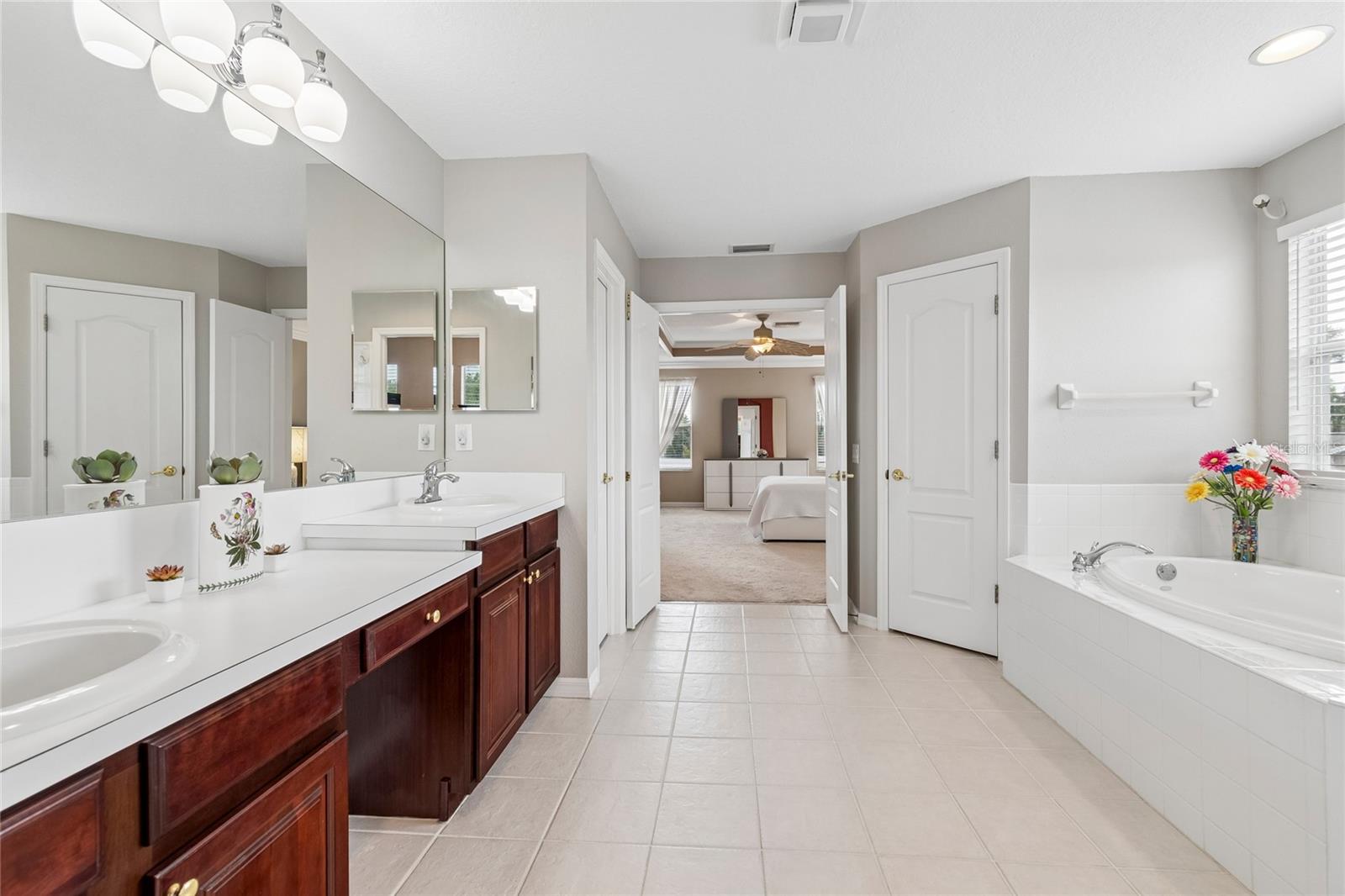 The spacious ensuite bathroom boasts plenty of natural light, garden tub, huge shower, double vanity and double closets