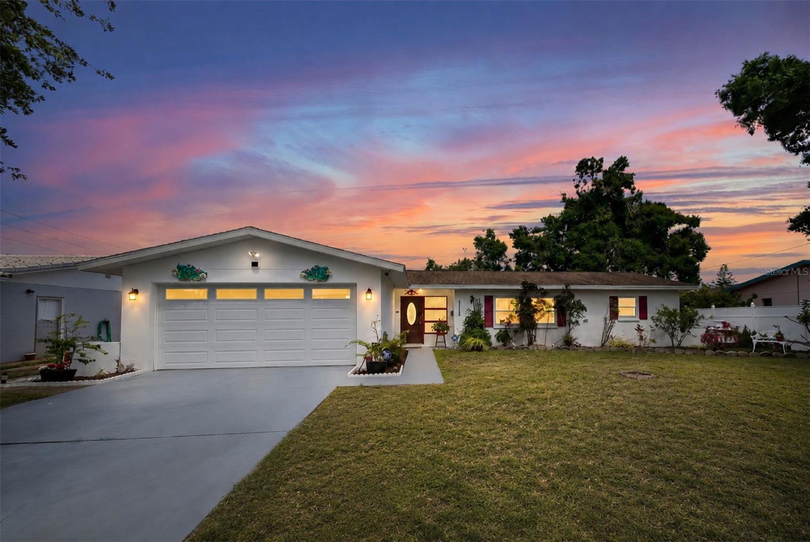 Coastal-inspired curb appeal with vibrant red accents and lush tropical landscaping