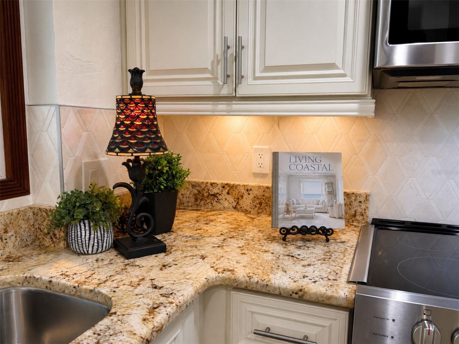 Intricate stone backsplash and soft-close cabinetry add designer touches
