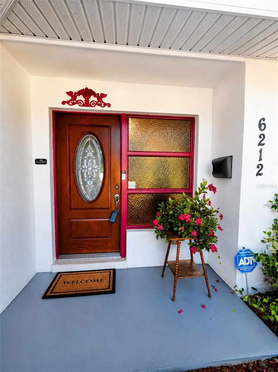 Rich wood entry door with decorative glass creates a warm first impression