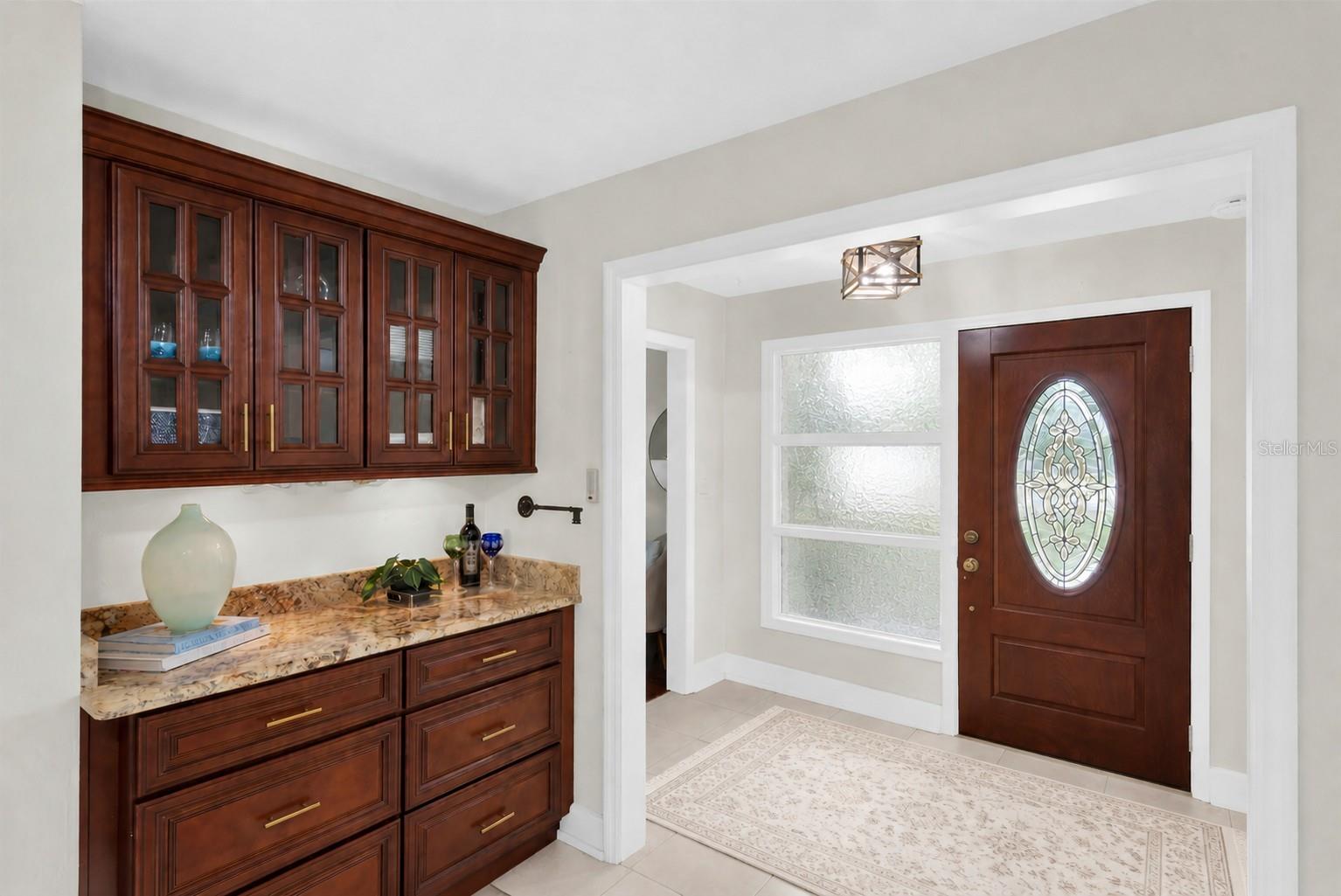 Family room with sophisticated dry bar and illuminated cabinetry