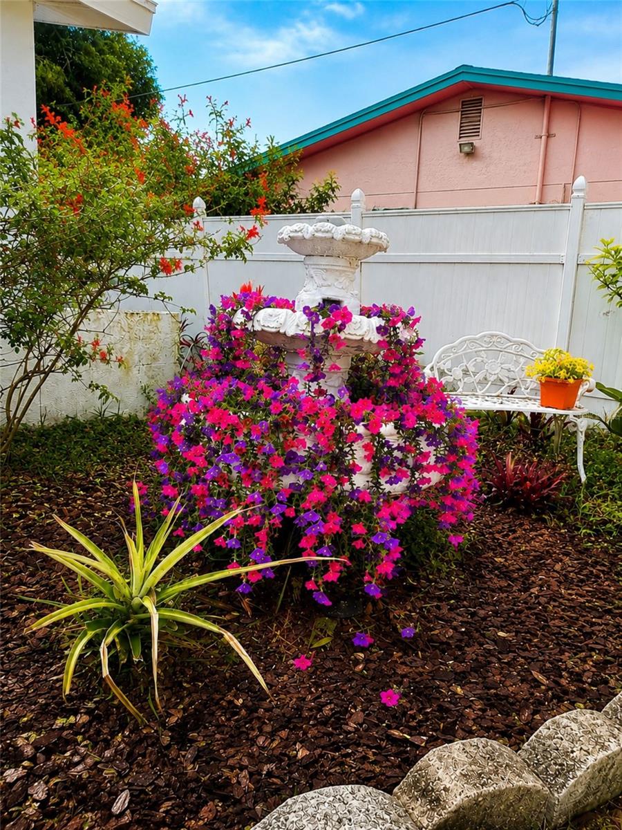 Charming white tiered fountain welcomes guests at the front entry