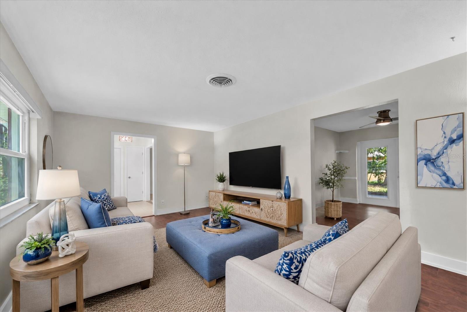 Spacious living room filled with natural light and flexible seating areas