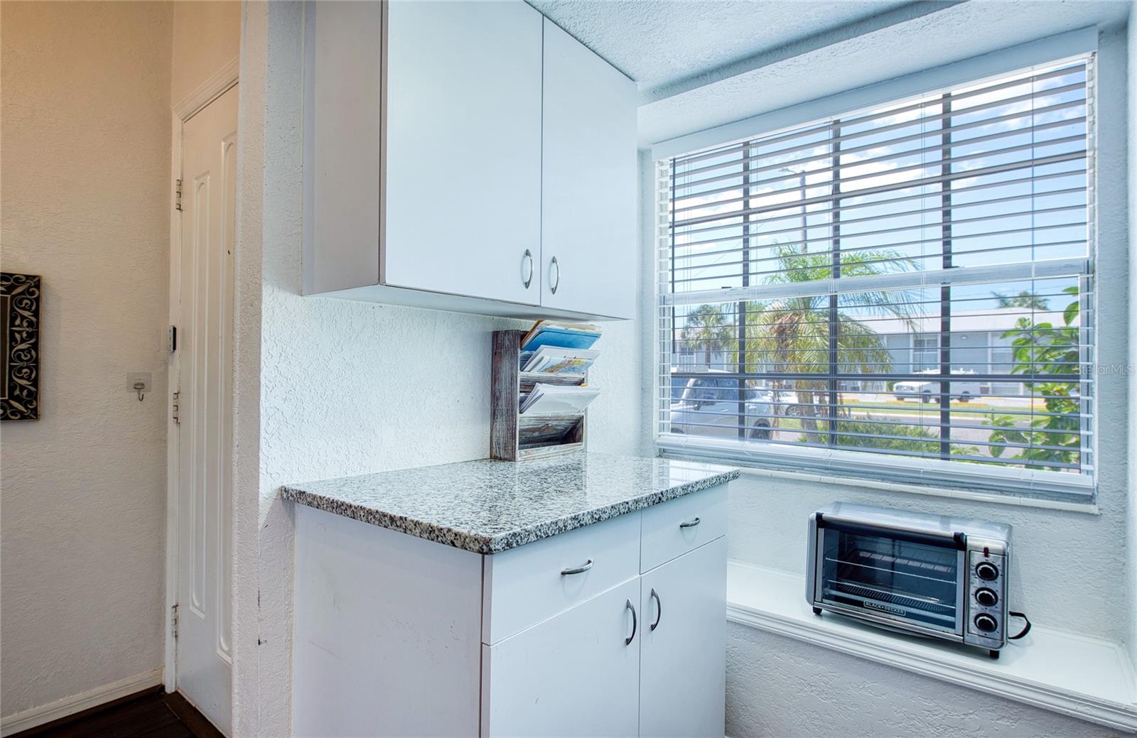 bench and extra cabinets with bay window for bright kitchen.