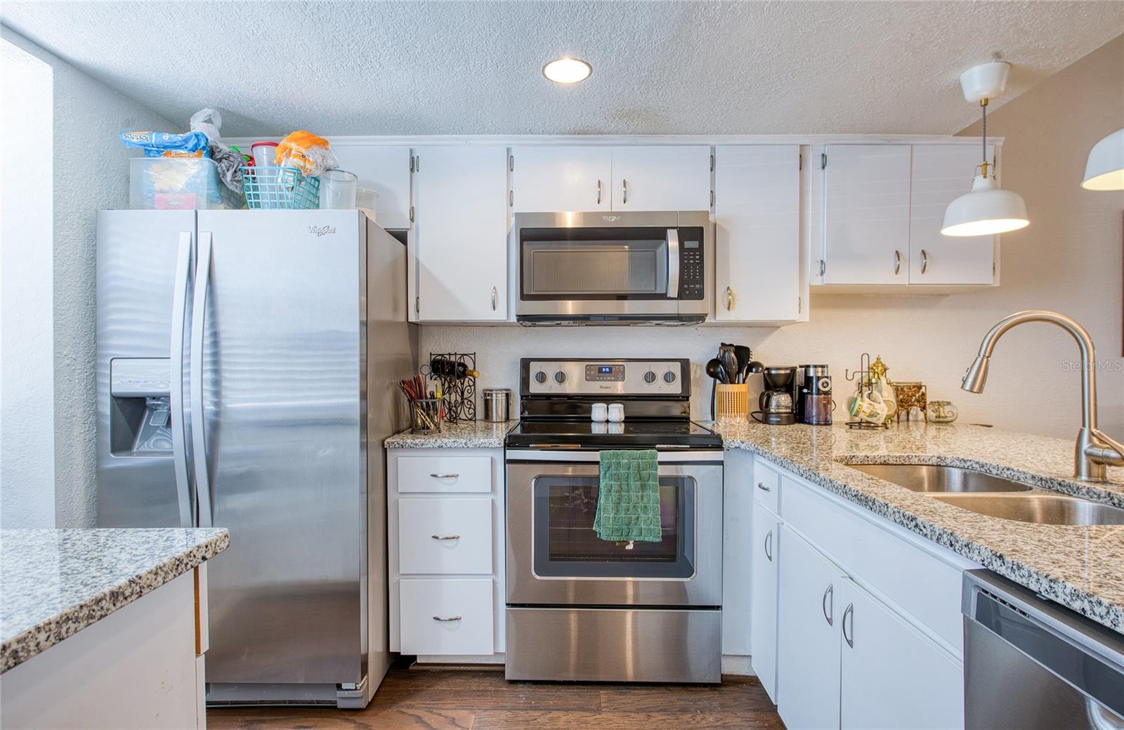 Spacious Kitchen with Granite countertops and whirlpool stainless steel appliances.