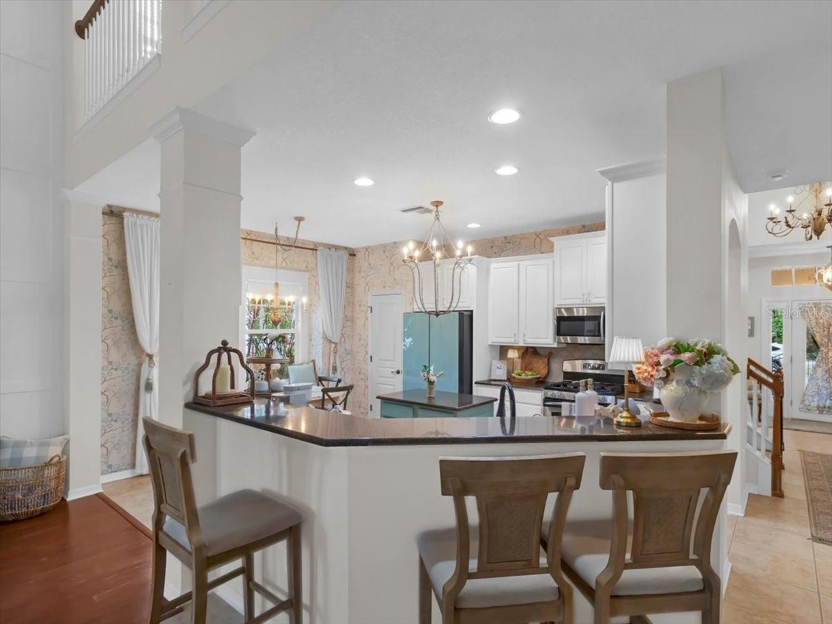 Breakfast Bar view shows the matching refrigerator, stainless appliances, and the door to the Walk in Pantry.
