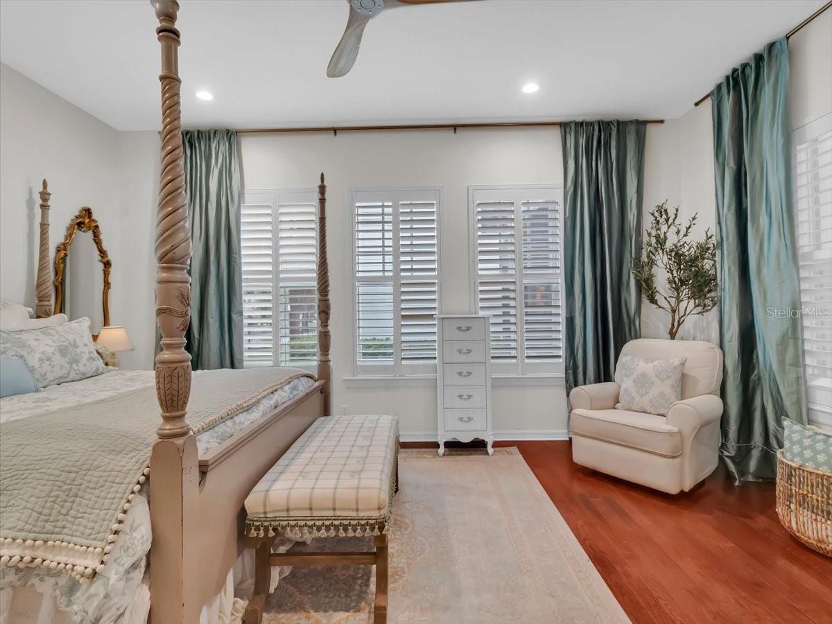 Primary Bedroom, features a Generous Floorplan, Plantation shutters, Hardwood floors, high ceilings!