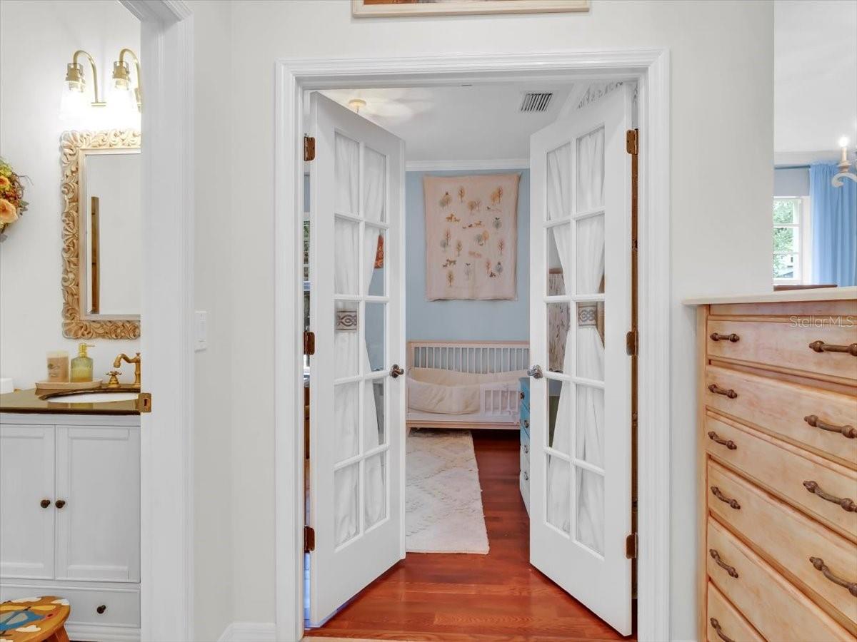 Half Bath in the Foyer . Double glass doors to the office/ 6th bedroom has the matching hardwood floors.