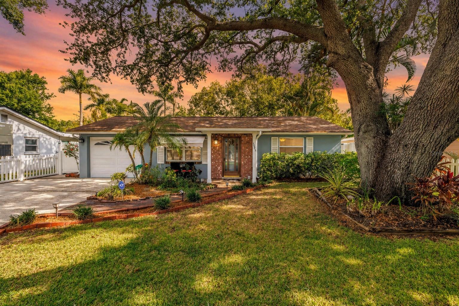 Charming curb appeal beneath a majestic oak canopy welcomes you home