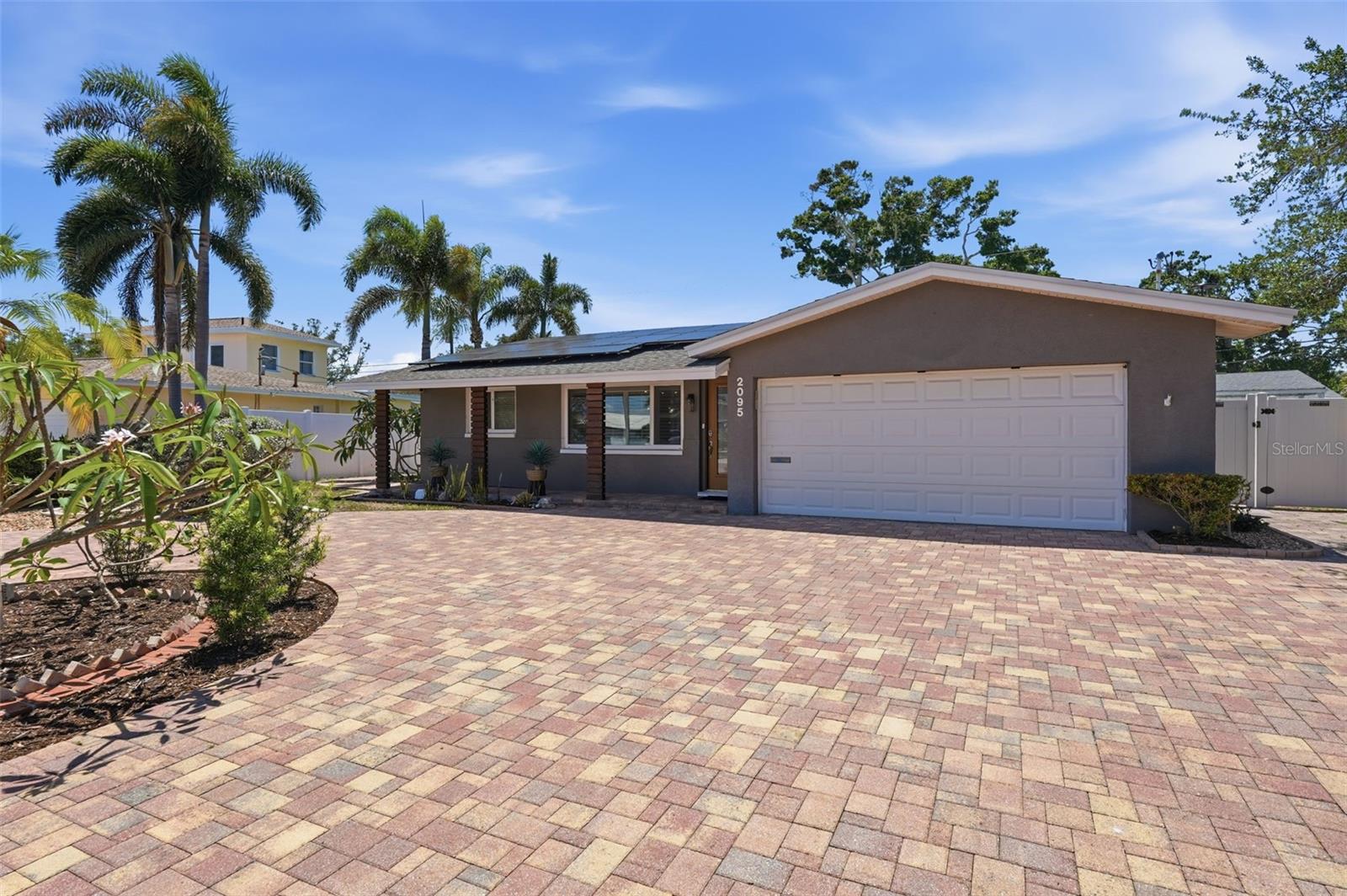 Bold curb appeal with an oversized paver driveway makes a statement before you even walk through the door.