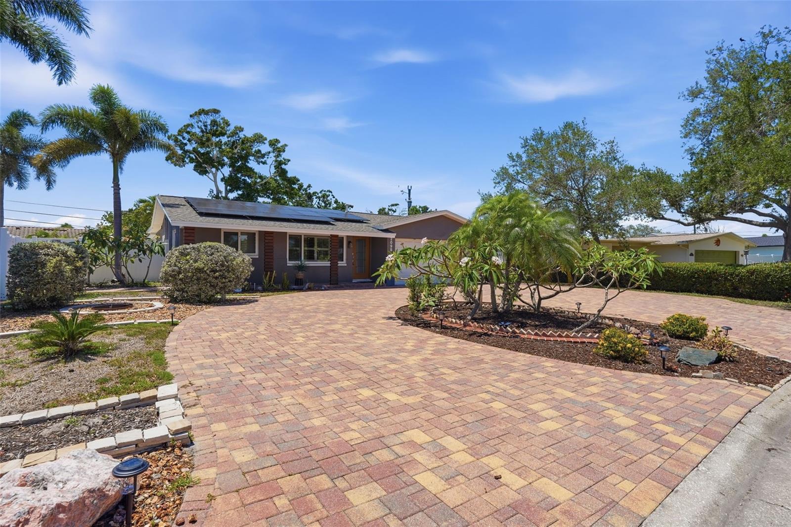 Bold curb appeal with an oversized paver driveway makes a statement before you even walk through the door.