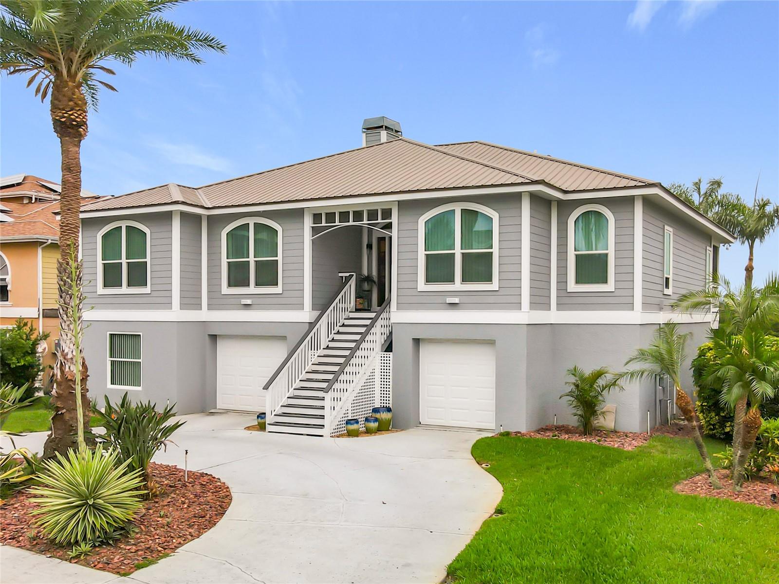 Welcome to your waterfront oasis! This captivating front exterior showcases beautiful landscaping and offers extra parking, perfect for embracing the joys of intercoastal living