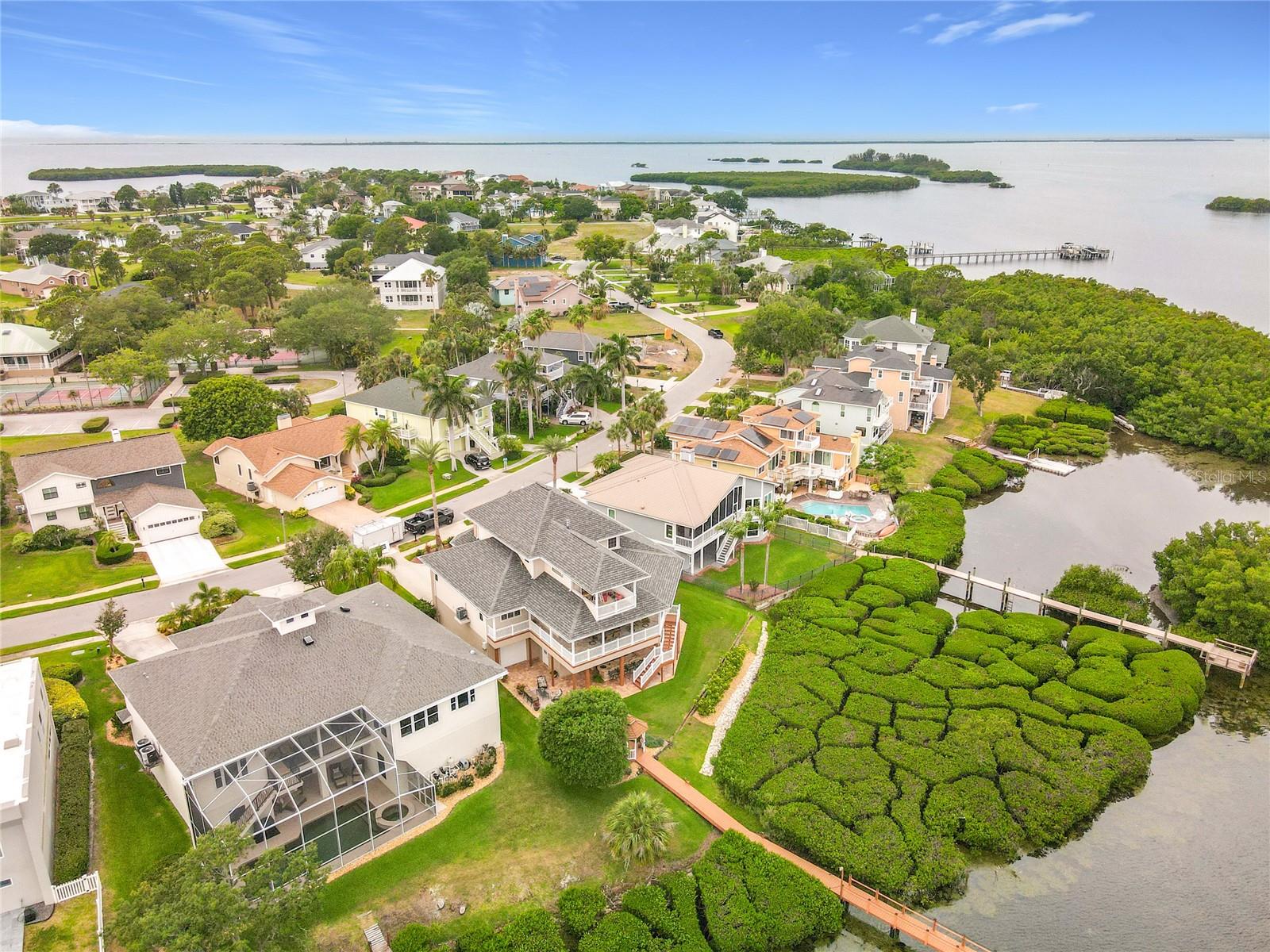 Capture the essence of coastal serenity with this stunning aerial view, highlighting the home's picturesque setting amid flourishing mangroves and the shimmering waterfront—where every moment feels like a vacation.