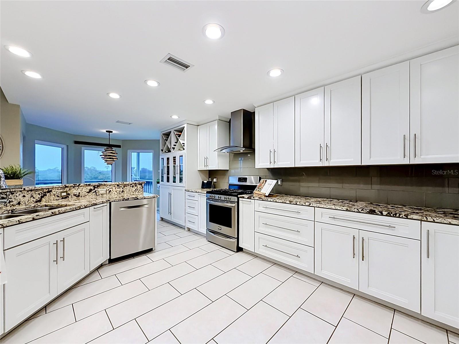 A chef's paradise, this beautifully bright kitchen showcases sleek white cabinetry and quartz countertops.