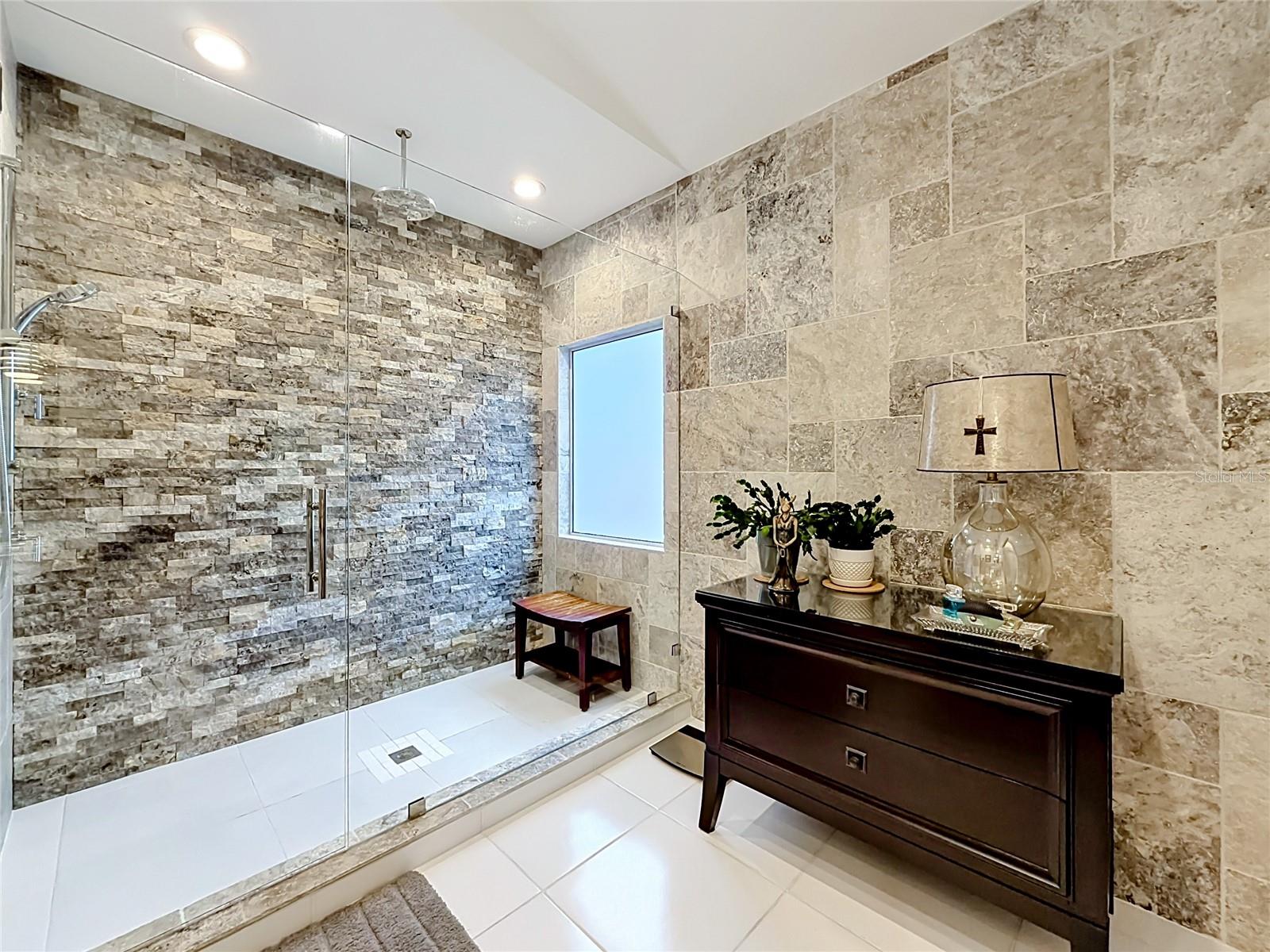 This stunning primary ensuite with a beautifully designed rain shower, creating a serene oasis that encapsulates your slice of paradise.