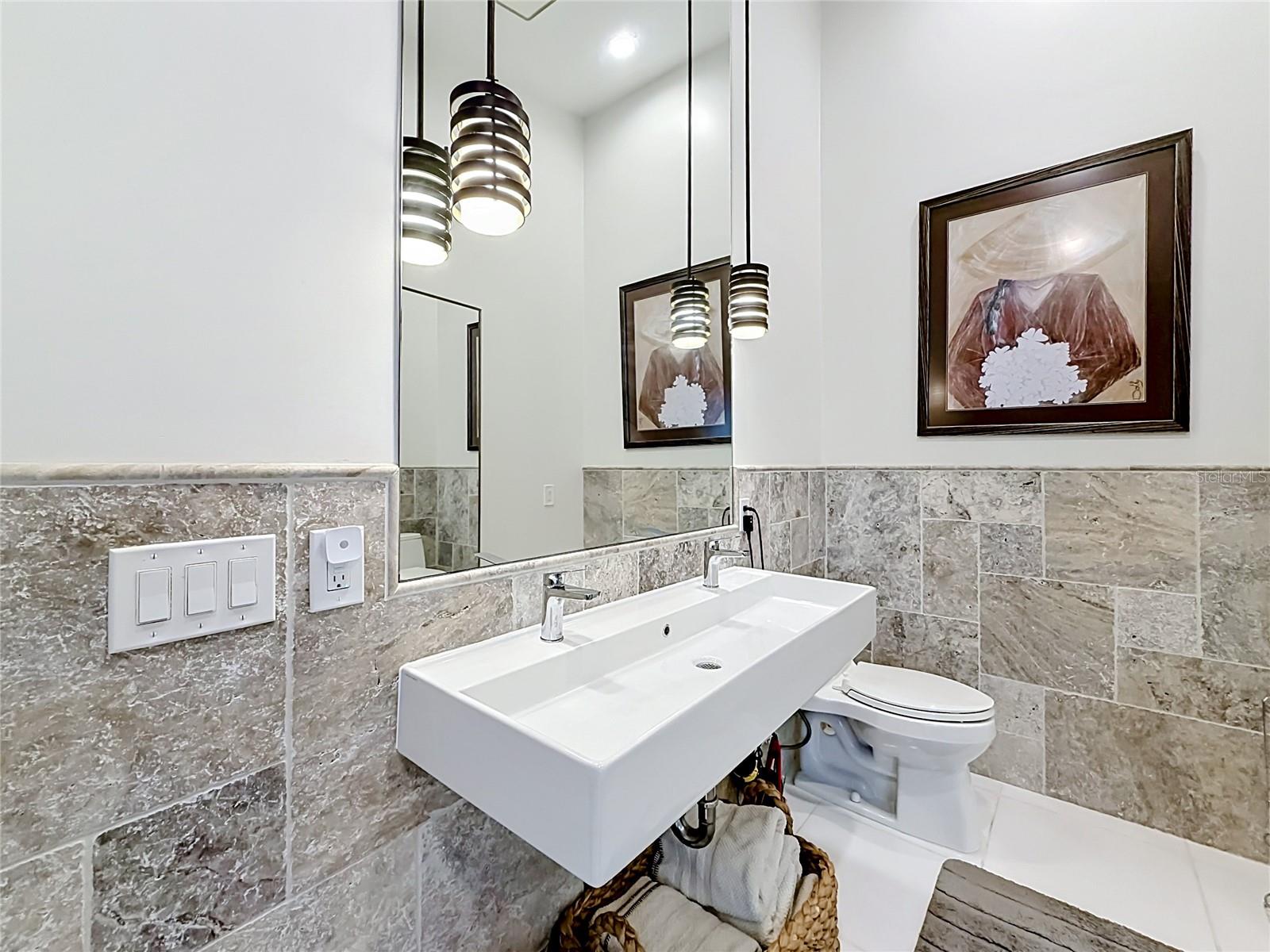 Step into modern elegance in this primary ensuite, where custom rain shower and sophisticated light fixtures harmonize to create a sleek sanctuary that defines contemporary luxury.