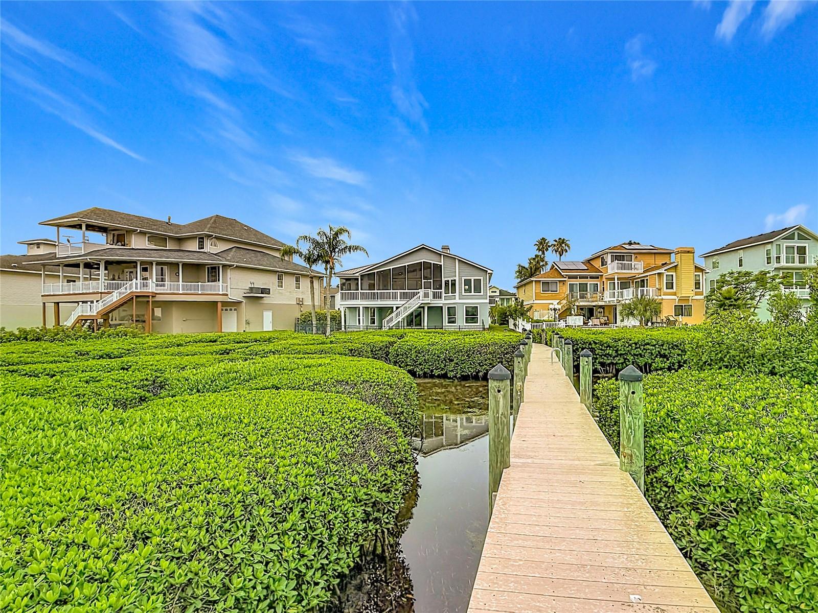 Stroll along this picturesque walkway, flanked by lush mangroves, leading you to your tranquil dock—each step envelops you in a resort-like ambiance, inviting you to embrace the serenity of your private waterfront oasis.