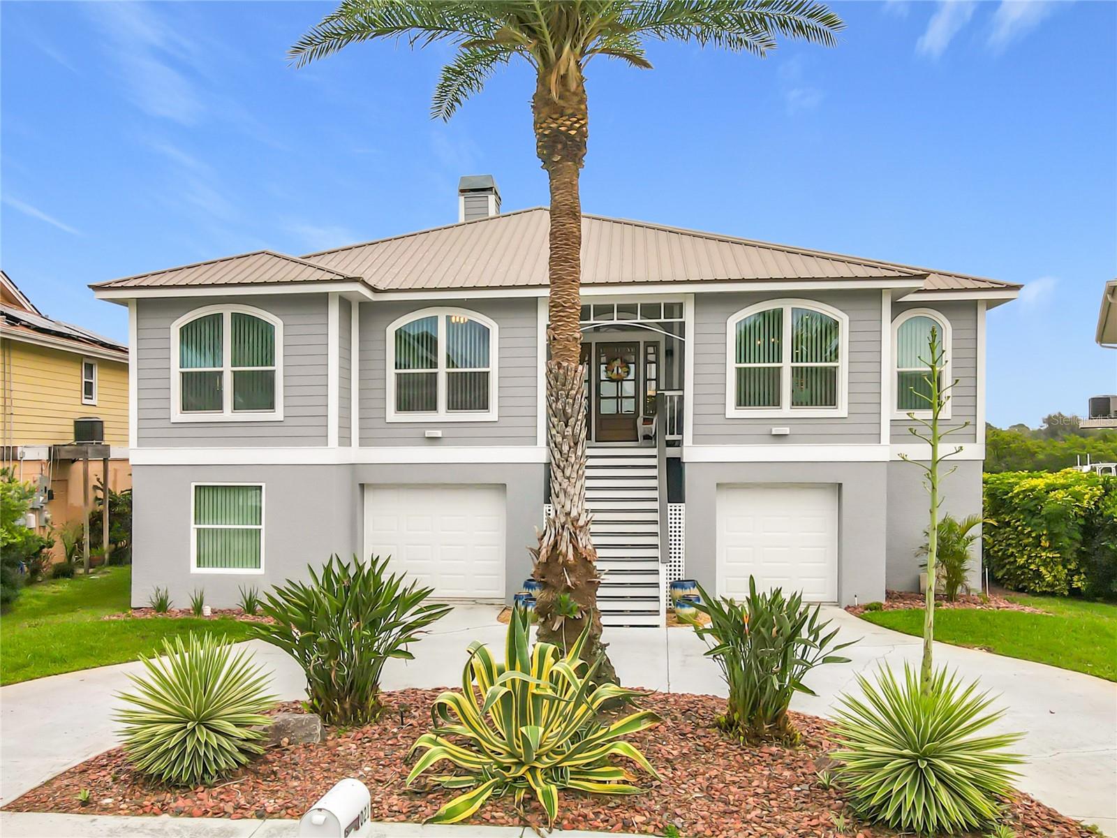 Experience the charm of waterfront living with this beautifully landscaped home, featuring exceptional curb appeal and generous parking—an inviting entry to your coastal paradise.