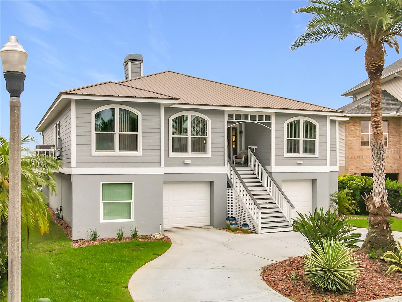 Welcome to your waterfront oasis! This captivating front exterior showcases beautiful landscaping and offers extra parking, perfect for embracing the joys of intercoastal living